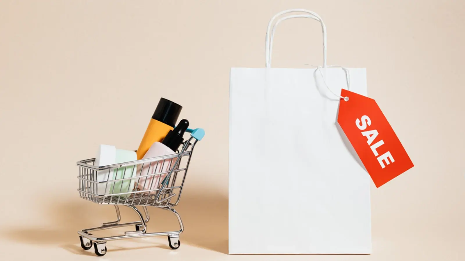 A shopping bag and miniature cart with products and a sale tag, representing retail and sales businesses.